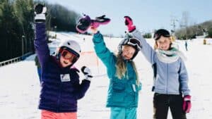 annual ski trip - students with hands raised in celebration