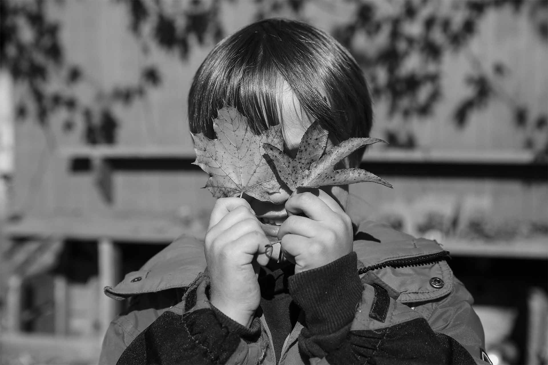 natural domain - student holding two leaves over his eyes