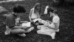 Outdoor learning activity with diverse children at Rainbow Community School, fostering creativity and inclusion.